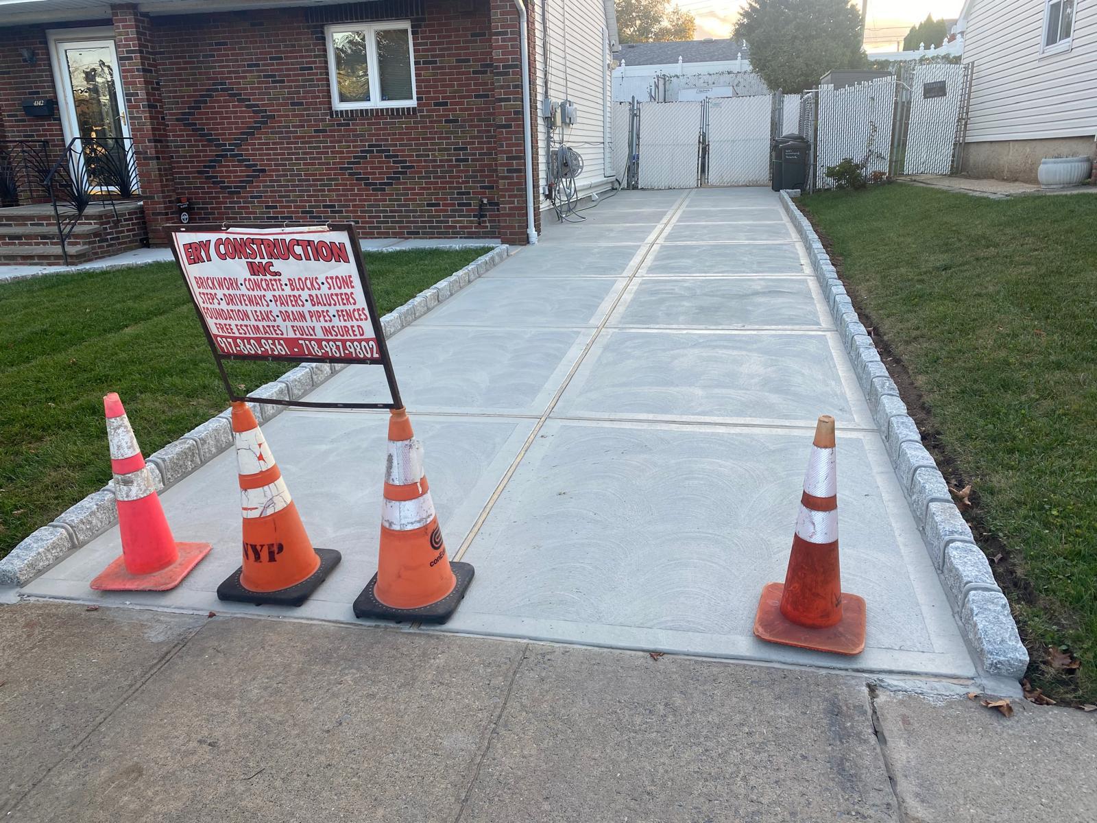 Completed sidewalk repair with cones and work signage